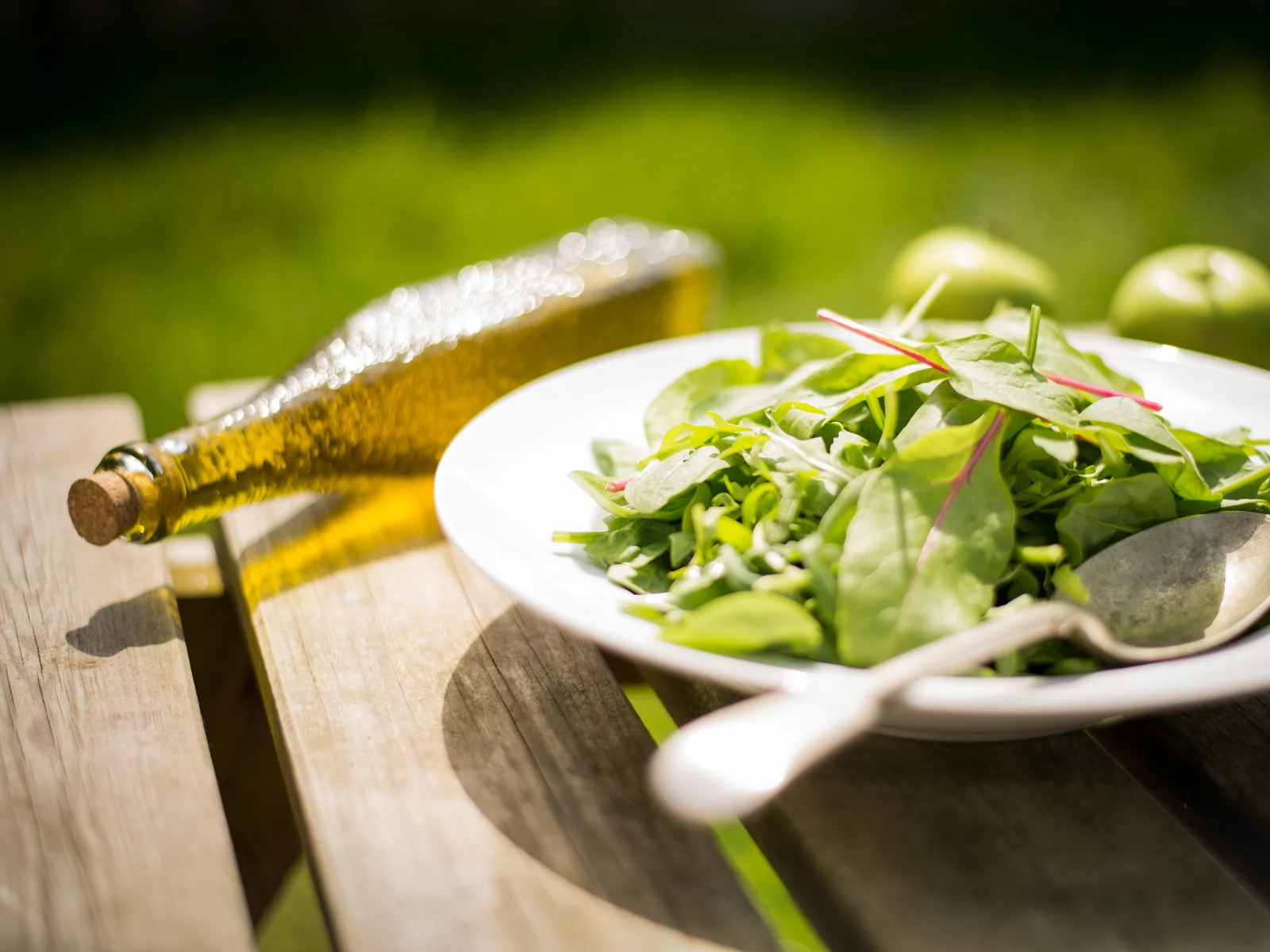 Zeytinyağı şişesinin yanında taze yeşil salata